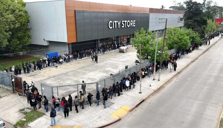 Una multitud  bajo la lluvia por uno de los 30 puestos de trabajo en un bazar