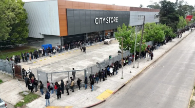 Una multitud  bajo la lluvia por uno de los 30 puestos de trabajo en un bazar